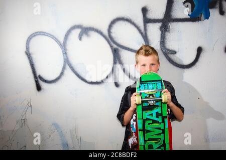 Auf diesem atemberaubenden Foto zeigen sich die Skateboard-Fähigkeiten eines blonden Jungen Stockfoto