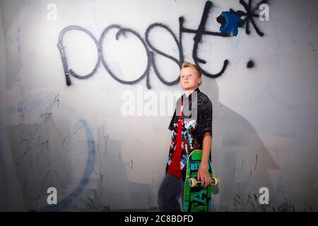 Auf diesem atemberaubenden Foto zeigen sich die Skateboard-Fähigkeiten eines blonden Jungen Stockfoto