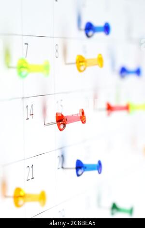 Bunte Stecknadeln auf weißem Kalender clsoe up, seichte dof Stockfoto