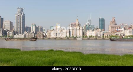 Shanghai, China - 19. April 2018: Panorama des Bundes mit grünem Gras und Huangpu Fluss im Vordergrund. Historische Gebäude von Shanghai. Stockfoto