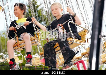 Kinder genießen die Fahrt auf einem Karussell an einem sonnigen Nachmittag im Heritage Park in Calgary, Alberta Stockfoto