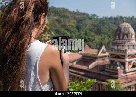 Junge Frau, die den indischen Tempel fotografiert, Goa, Indien Stockfoto