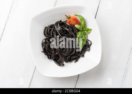 Teller mit köstlicher Linguine mit Tintenfisch-Sauce, ein typisches Rezept der italienischen Pasta Stockfoto