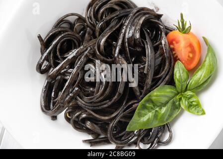 Teller mit köstlicher Linguine mit Tintenfisch-Sauce, ein typisches Rezept der italienischen Pasta Stockfoto