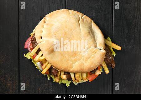 Draufsicht auf Pitta Brot gefüllt mit Salat, Tomaten, Zwiebeln, pommes Frites und Lamm Stockfoto