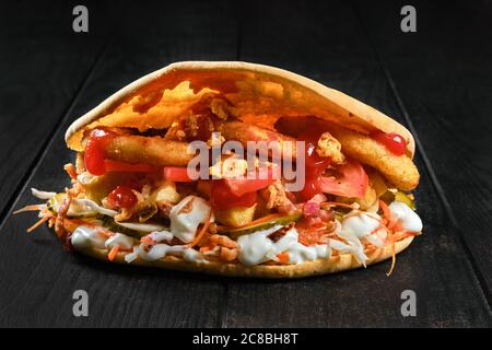 Pitta-Brot gefüllt mit würzigen Karotten, Tomaten, Zwiebeln, eingelegte Gurken und Huhn Stockfoto