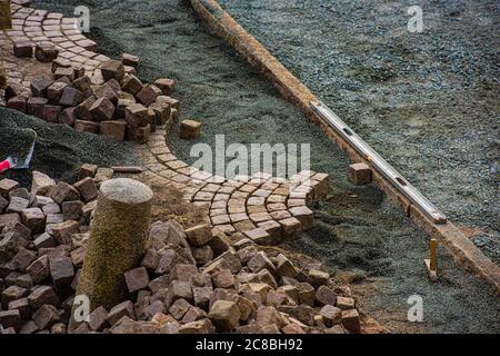 Pflasterstein wird entfernt, um einen neuen Abschnitt des Pflasters zu machen. Stockfoto