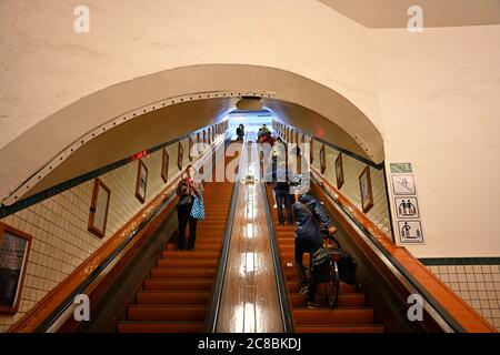 antwerpen, belgien - 2020.07.14: Menschen mit ihren Fahrrädern auf der Rolltreppe des rechten scheldtbänke Eingang des st anna Fußgängertunnels von 1933 bei sint- Stockfoto