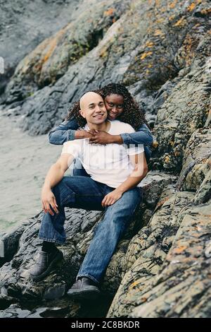 Romantisches Paar am felsigen Ufer lachen und verbinden. Stockfoto