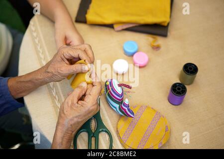 Ältere Frau mit Betreuer in der Nadel Handwerk Ergotherapie für Alzheimer oder Demenz Stockfoto