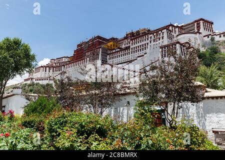 Lhasa, Tibet / China - 31. Jul 2017: Potala Palast im Sommer. Mit grünen Büschen im Vordergrund. Stockfoto