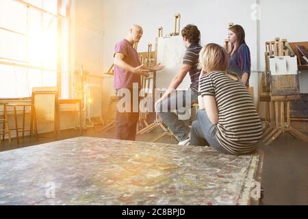 Künstler, die im Studio mit jungen Künstlern sprechen Stockfoto