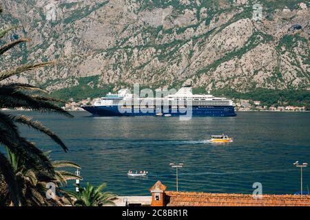 Ein riesiger Kreuzfahrtschiff mit mehreren Deck in der Bucht von Kotor, vor der Kulisse eines Berges über der Stadt Dovrota und Ljuta in Montenegro. Stockfoto