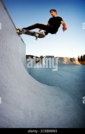 Boy Skateboarding in einem Skatepark am Nachmittag Stockfoto