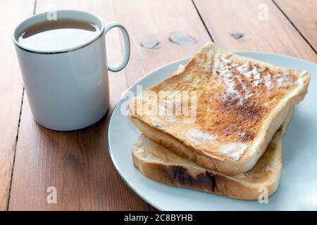 Tee und Toast auf einem rustikalen Holztisch Stockfoto