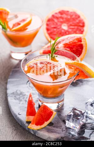 Frisches, rosa Grapefruit Getränk mit Saft. Kalte Sommer Zitrusfrucht erfrischende Getränk oder Getränke mit Rosmarin. Stockfoto
