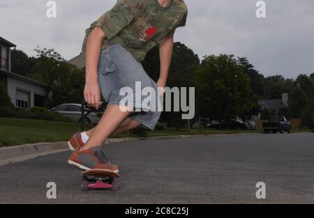 Zugeschnittenes Foto von Kind Reiten Skateboard Stockfoto