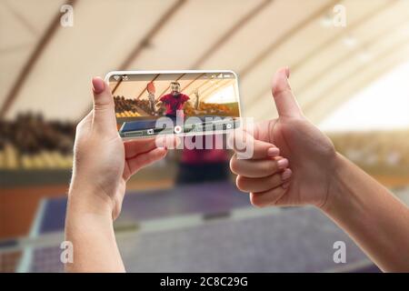 Nahaufnahme Hände halten Smartphone Sport, Tennis Online-Streaming von Meisterschaft. Neue Regeln während des Coronavirus-Ausbruchs und Ländersperre. Konzept von Sport, Wettbewerb, Technologien. Stockfoto