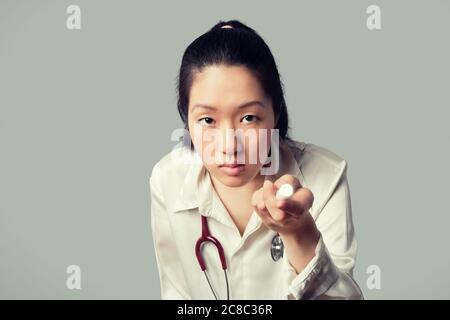Junge asiatische weibliche Arzt hält eine Taschenlampe Stockfoto