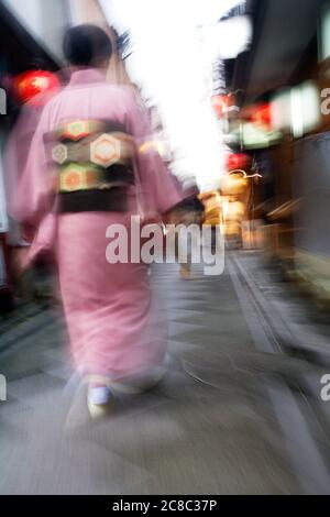 Japan Kyoto Pontocho-dori Frau trägt Kimono beim gehen auf engen Straßen Bewegungsunschärfe Stockfoto