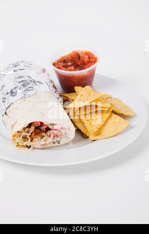 Mexikanischer Burrito und Nachos zum Mittagessen auf dem Teller Stockfoto