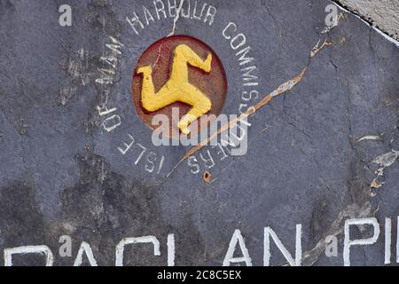 Hafenkommissare der Isle of man unterschreiben mit drei Beinen Logo am Hafen von Port Erin Stockfoto