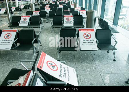 HEATHROW LONDON, GROSSBRITANNIEN. Juli 2020. 23 Hinweise zur öffentlichen Gesundheit auf den Sitzen im Flughafenterminal von Heathrow werden soziale Distanzierungsschilder angebracht, um zu verhindern, dass Passagiere während der Coronavirus-Pandemie zu eng beieinander sitzen, um die Ausbreitung von Covid-19-Infektionen zu stoppen. Kredit: amer ghazzal/Alamy Live Nachrichten Stockfoto