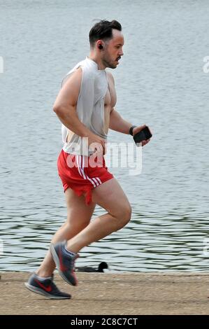 London, UK, 23. Juli 2020 Jogger an der Seite des Serpentine. Hyde Park bereitet sich auf einen anstrengenden sonnigen Tag vor, da die Sperrung durch Coronaviren nachlässt. Kredit: JOHNNY ARMSTEAD/ Alamy Live Nachrichten Stockfoto