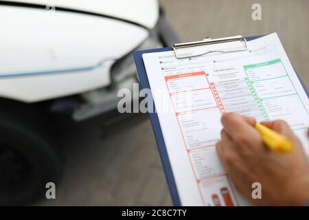 Agent erstellt nach einem Autounfall einen versicherten Vorfall. Stockfoto