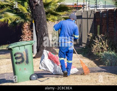 Alberton, Südafrika - nicht identifizierte schwarze Männer arbeiten als Gelegenheitsarbeiter, die Gartenarbeit in einem Wohngarten leisten Stockfoto