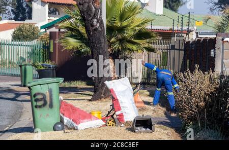 Alberton, Südafrika - nicht identifizierte schwarze Männer arbeiten als Gelegenheitsarbeiter, die Gartenarbeit in einem Wohngarten leisten Stockfoto