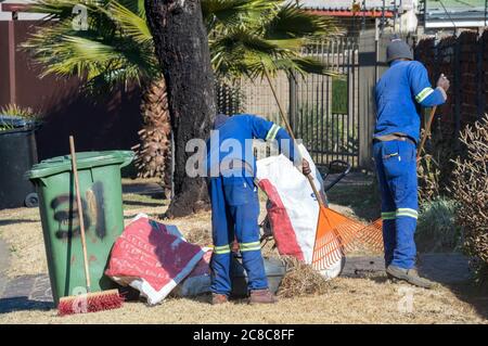 Alberton, Südafrika - nicht identifizierte schwarze Männer arbeiten als Gelegenheitsarbeiter, die Gartenarbeit in einem Wohngarten leisten Stockfoto