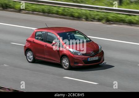 Ein 2013 Toyota Yaris TR VVT-I Red Car Hatchback Benzin auf der M6 Autobahn in der Nähe von Preston in Lancashire, Großbritannien Stockfoto