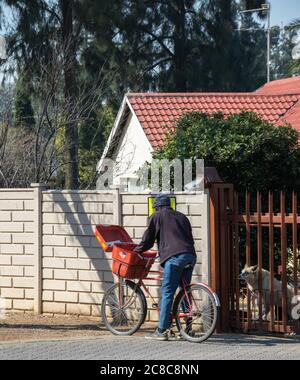 Alberton, Südafrika - der Familienhund ist nicht glücklich mit dem nicht identifizierten Postmann, der Post an das Heimatbild in horizontalem Format liefert Stockfoto