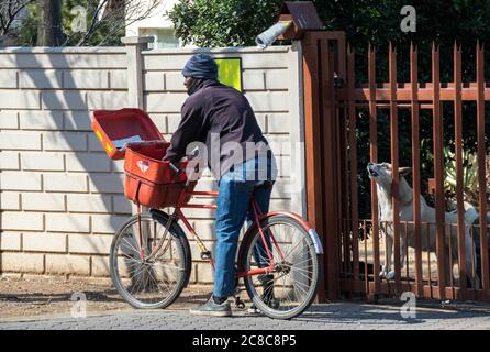 Alberton, Südafrika - der Familienhund ist nicht glücklich mit dem nicht identifizierten Postmann, der Post an das Heimatbild in horizontalem Format liefert Stockfoto