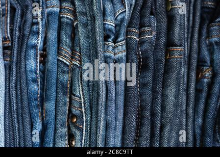 Stapel von blauen Jeans in verschiedenen Schattierungen. Jeans Hintergrund. Nahaufnahme. Weichfokus Stockfoto