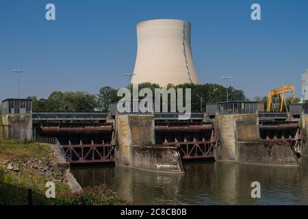 Drei Schleusen eines Wasserkraftwerks mit Maschinenhaus. Und im Hintergrund ein Kühlturm eines Kernkraftwerks. Stockfoto