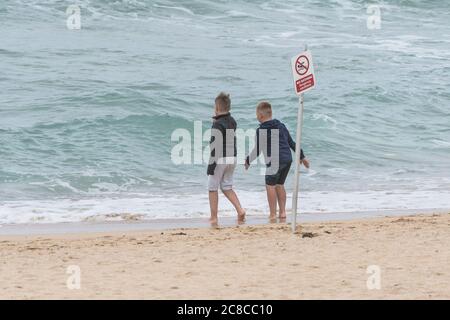 Zwei kleine Jungs paddeln und Spaß am Fistral Beach in Newquay in Cornwall. Stockfoto