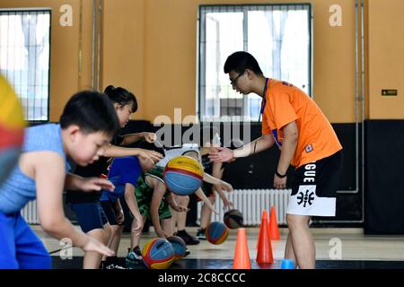 Tianjin, China. Juli 2020. Kinder besuchen während der Sommerferien im pko Sports Complex in Tianjin, Nordchina, am 23. Juli 2020 einen Basketballkurs. Der PKO Sports Complex, der aus einer ehemaligen Fabrik für ausrangierte Zwecke wurde, bietet Einrichtungen wie einen Käfigfußballplatz, eine Basketballhalle, eine Tischtennishalle und ein Kampfkunstklassenzimmer. Er bietet sowohl Sportplätze für die Bewohner in der Nähe als auch mehrere Sporttrainingskurse für die Schüler im Urlaub. Kredit: Li Ran/Xinhua/Alamy Live Nachrichten Stockfoto