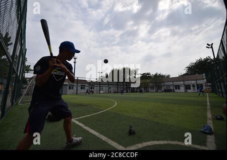 Tianjin, China. Juli 2020. Ein Junge besucht während der Sommerferien im pko Sports Complex in Tianjin, Nordchina, am 23. Juli 2020 einen Baseball-Trainingskurs. Der PKO Sports Complex, der aus einer ehemaligen Fabrik für ausrangierte Zwecke wurde, bietet Einrichtungen wie einen Käfigfußballplatz, eine Basketballhalle, eine Tischtennishalle und ein Kampfkunstklassenzimmer. Er bietet sowohl Sportplätze für die Bewohner in der Nähe als auch mehrere Sporttrainingskurse für die Schüler im Urlaub. Kredit: Sun Fanyue/Xinhua/Alamy Live Nachrichten Stockfoto