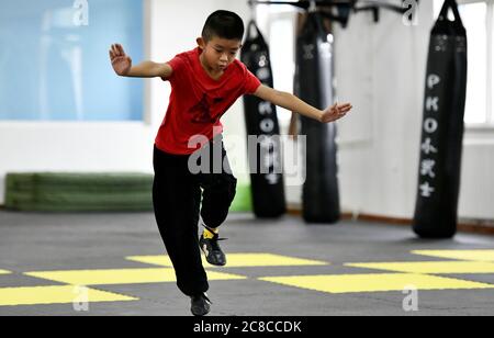 Tianjin, China. Juli 2020. Ein Junge besucht während der Sommerferien im pko Sports Complex in Tianjin, Nordchina, am 23. Juli 2020 einen Kampfkunstkurs. Der PKO Sports Complex, der aus einer ehemaligen Fabrik für ausrangierte Zwecke wurde, bietet Einrichtungen wie einen Käfigfußballplatz, eine Basketballhalle, eine Tischtennishalle und ein Kampfkunstklassenzimmer. Er bietet sowohl Sportplätze für die Bewohner in der Nähe als auch mehrere Sporttrainingskurse für die Schüler im Urlaub. Kredit: Li Ran/Xinhua/Alamy Live Nachrichten Stockfoto