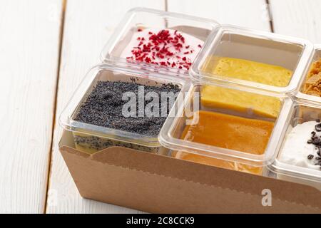 Auswahl an leckeren Dessertboxen auf Holztisch Stockfoto