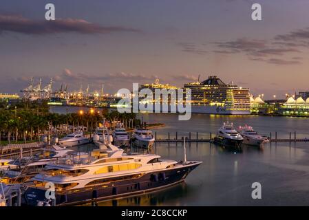 Miami, Florida, USA - 8. Januar 2020 : MSC Divina Kreuzfahrtschiff im Hafen von Miami bei Sonnenuntergang mit mehreren Luxusyachten im Vordergrund. Stockfoto