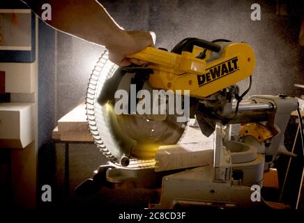 Kiew, Ukraine - 22.07.2020: Zimmermann schneidet Holzbrett mit einer Gehrungsäge DeWalt, eine berühmte amerikanische Marke. Stockfoto