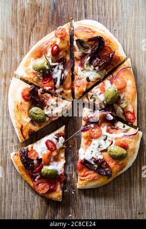 Hausgemachte vegane Pizza auf Holzbrett Stockfoto