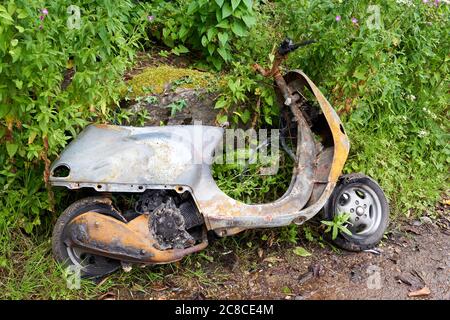 Ein ausgebranntes Moped, das an einer Straßenseite, Cardiff, Südwales, aufgegeben wurde Stockfoto