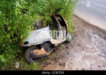 Ein ausgebranntes Moped, das an einer Straßenseite, Cardiff, Südwales, aufgegeben wurde Stockfoto