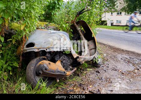 Ein ausgebranntes Moped, das an einer Straßenseite, Cardiff, Südwales, aufgegeben wurde Stockfoto