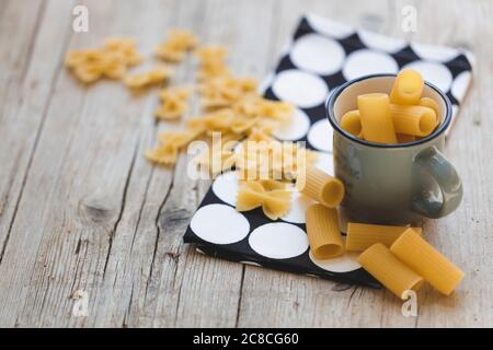 Verschiedene Arten von Eiernudeln und gelbe Pasta auf Holzgrund Stockfoto