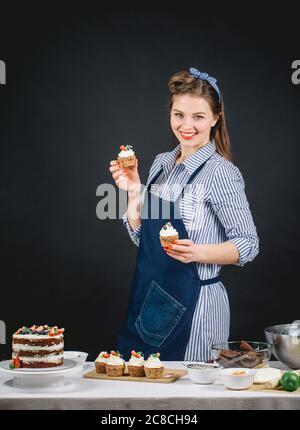 Schöne Konditorin Frau hält frisch gebackene Cupcakes in den Händen, Werbung für gesunde zuckerfreie Süßigkeiten Stockfoto